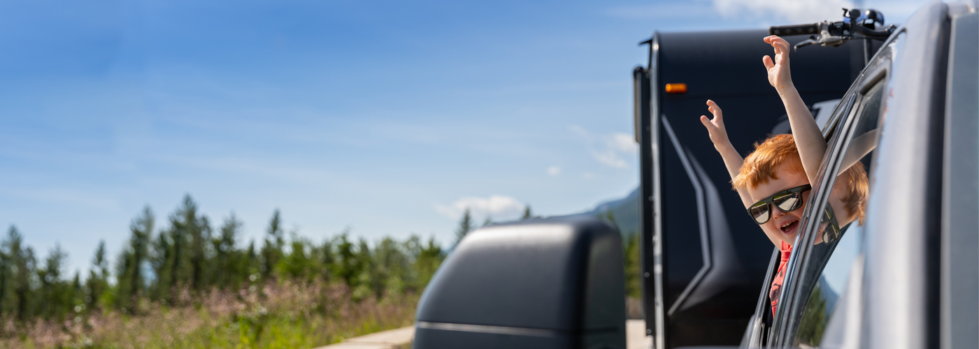 Man sitting in pickup truck with window rolled down and holding out keys to the vehicle.